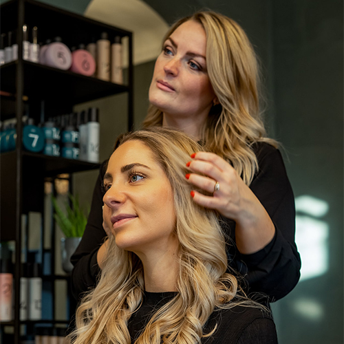 Frisør Amalie Chris der styler en blond model
